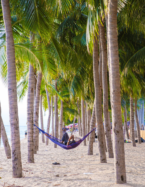 Dong Tan Beach Jomtien Pattaya Thailand during afternoon sunset. hammock between palm trees on the beach - Photo, image