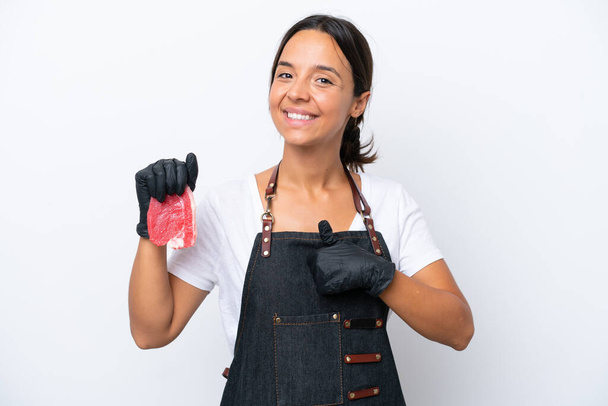 Butcher hispanic woman wearing an apron and serving fresh cut meat isolated on white background giving a thumbs up gesture - Photo, image