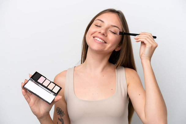 Young Lithuanian woman isolated on white background with makeup palette and happy - Fotoğraf, Görsel