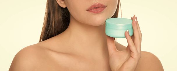 ritagliato giovane donna tenere crema vaso per la pelle del viso isolato su sfondo bianco, pubblicità. - Foto, immagini
