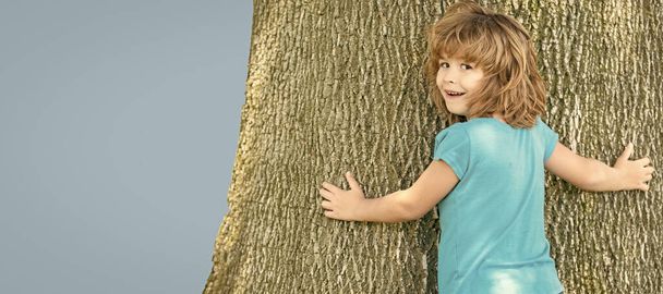 Se on niin leveä. Poika yrittää kiivetä puuhun. Lapsuus ja poikuus. Poikakaudet. Puu kiipeää. Vaaka juliste suunnittelu. Web bannerin otsikko, kopioi tilaa - Valokuva, kuva
