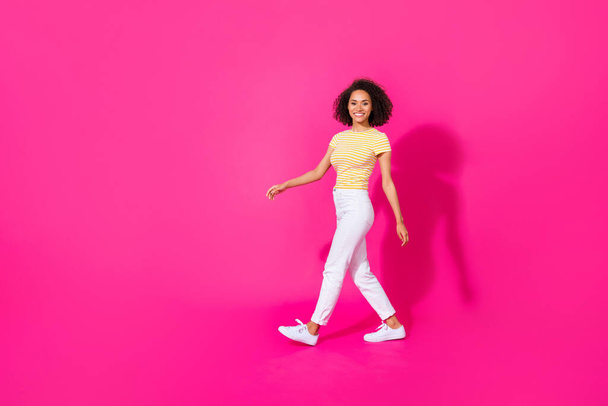 Ful size photo of pretty young lady walking shopping mall sales dressed stylish yellow striped look isolated on shine pink color background. - Fotografie, Obrázek