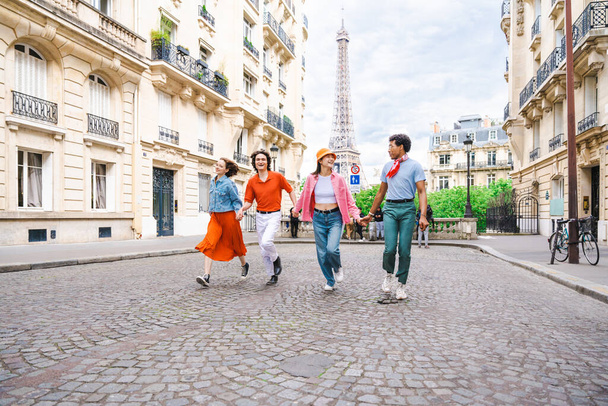 Group of young happy friends visiting Paris and Eiffel Tower, Trocadero area and Seine river - Multicultural group of tourists sightseeing the France capital city - Foto, afbeelding