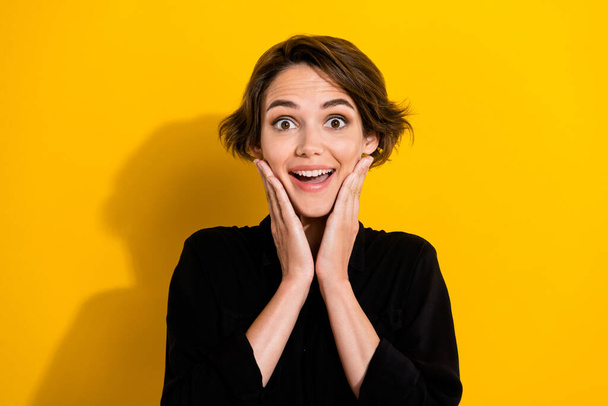 Photo of impressed young short hair lady wear black shirt isolated on yellow color background. - Foto, Bild