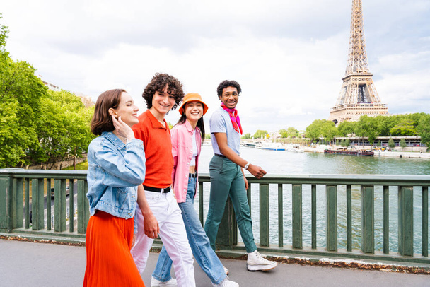 Group of young happy friends visiting Paris and Eiffel Tower, Trocadero area and Seine river - Multicultural group of tourists sightseeing the France capital city - Photo, image