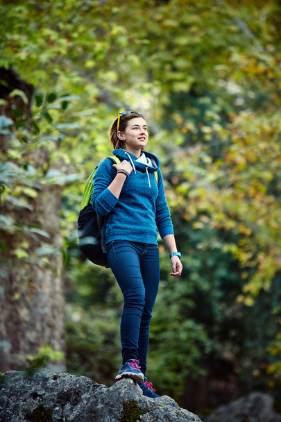 Woman hiker smiling standing outside in forest with backpack - 写真・画像