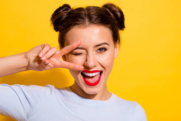 Photo of adorable good mood cheerful female showing v sign flirting with boyfriend isolated on yellow color background. - Fotó, kép