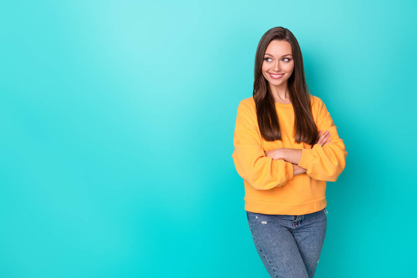 Photo of young adorable gorgeous nice pretty woman wear yellow sweatshirt folded arms toothy look empty space interested offer isolated on cyan color background. - Foto, immagini