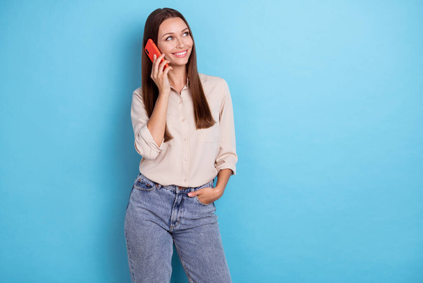Photo of lovely satisfied person lady speak communicate telephone interested look empty space isolated on blue color background. - Photo, image