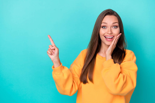 Photo of young adorable pretty nice girl wear yellow pullover touch cheeks surprised finger point empty space good news isolated on yellow color background. - Fotó, kép