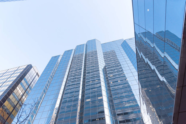 Reflexão do arranha-céu e cooperar edifícios de escritórios em paredes de vidro no centro de Oklahoma City, EUA céu azul claro. Baixo ângulo vista fa ade exterior de torres modernas de elevação - Foto, Imagem