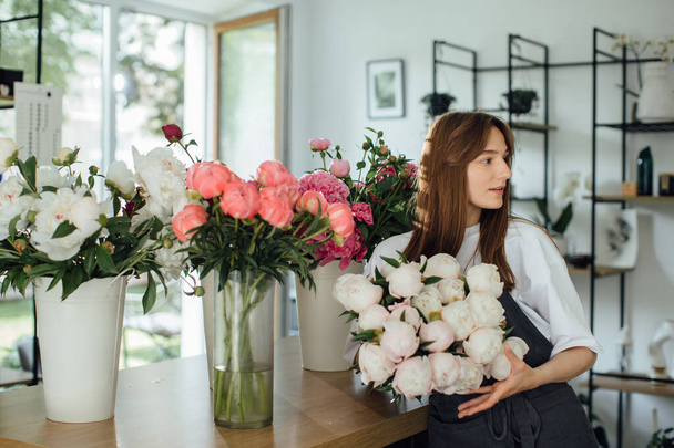 Florista mulher no espaço de trabalho da loja de flores. - foto stock - Foto, Imagem