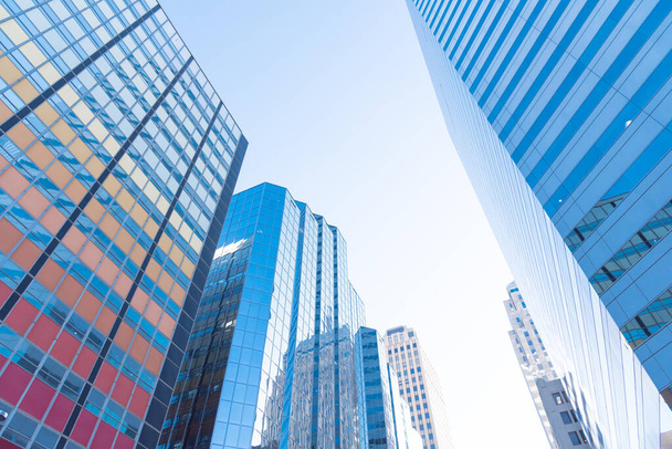 Отражение небоскребов и кооперативных офисных зданий на стеклянных стенах в центре Оклахома-Сити, США ясное голубое небо. Низкий угол обзора фаада экстерьера современных высотных башен - Фото, изображение