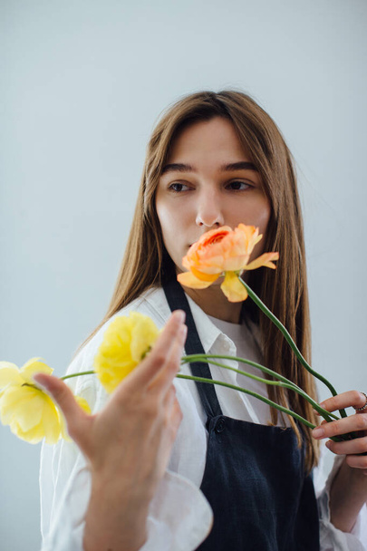 Женщина нюхает цветы во время организации его в цветочный магазин - фондовый фот - Фото, изображение