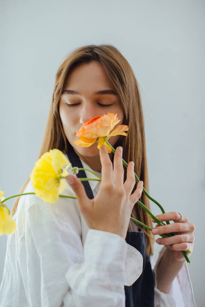 Vrouw ruiken bloemen tijdens het regelen van het in de bloemenwinkel - stock phot - Foto, afbeelding