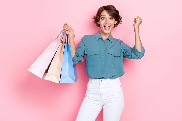 Foto della ragazza felice alzare il pugno successo basso prezzo promo tenere borse isolate su sfondo di colore rosa. - Foto, immagini