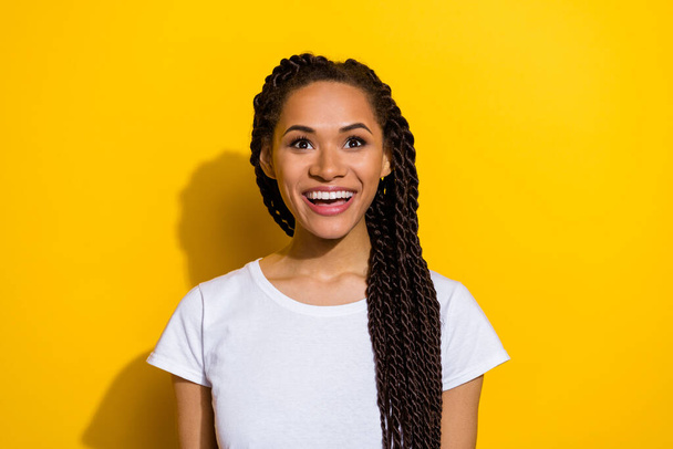 Portrait of excited astonished cheerful girl look interested up empty space isolated on yellow color background. - 写真・画像
