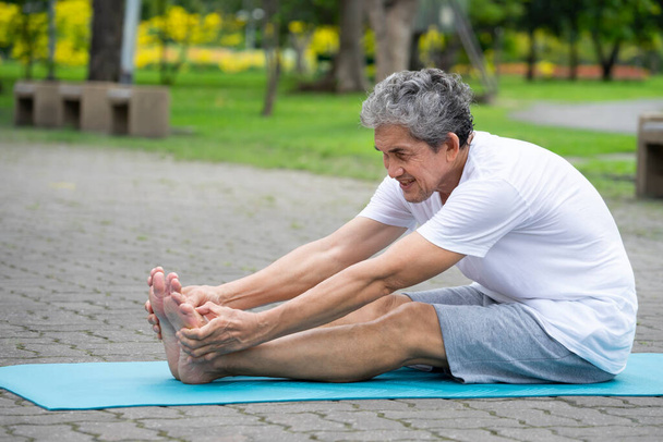 feliz hombre mayor haciendo yoga al aire libre en el parque  - Foto, Imagen