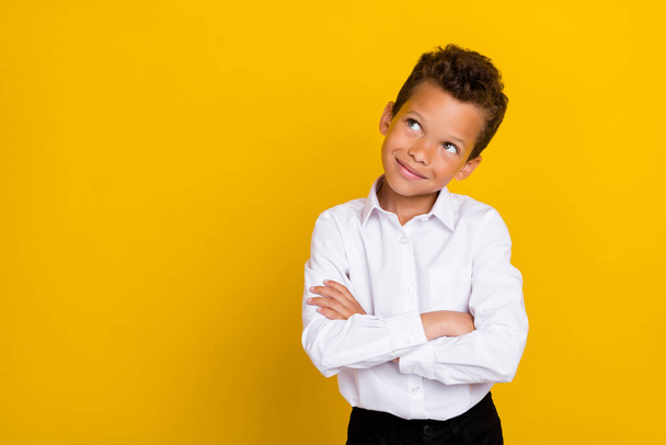 Photo of nice smart clever boy arm folded interested look up empty space choice choose consider dilemma isolated on yellow color background. - Photo, image