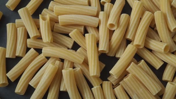 Raaka italialainen penne rigate pasta eristetty mustalla taustalla - Materiaali, video