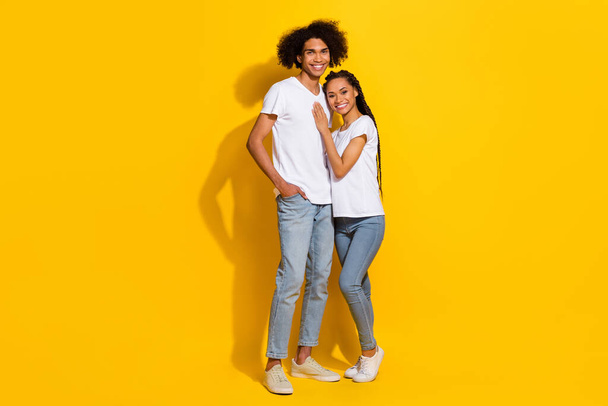 Full size portrait of two peaceful idyllic people cuddle toothy smile isolated on yellow color background. - Foto, Imagem