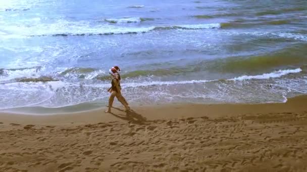 Christmas Beach Vacation Traveling Women in Santa 's Hat and Bikini Desfrute de pausas de inverno na praia tropical. As meninas caminham pelo mar e desfrutam de vistas. Fotografia aérea ou drone - Filmagem, Vídeo