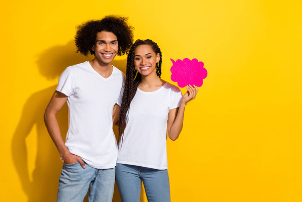 Portrait of attractive lady handsome guy hold empty space cloud bubble isolated on yellow color background. - Fotó, kép