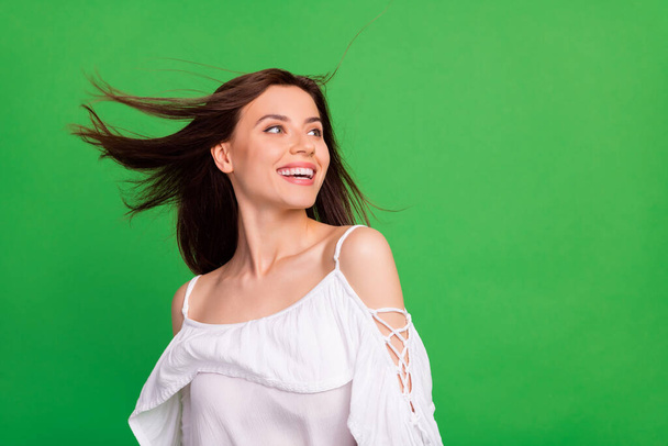 Portrait of cheerful pretty person beaming smile flying hair look empty space isolated on green color background. - Foto, Imagen