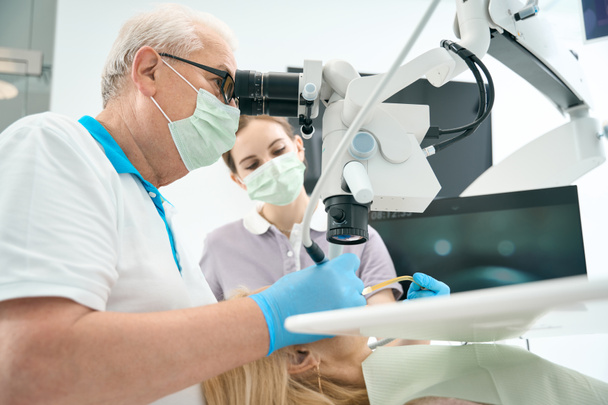 Professional stomatologist käyttäen erityistä kone ja varusteet hampaiden täyttämiseen - Valokuva, kuva