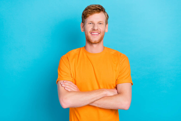 Foto von gut aussehenden fröhlich zufriedenen Mann mit Ingwerfrisur gekleidet gelben T-Shirt Arme isoliert auf türkisfarbenem Hintergrund gekreuzt. - Foto, Bild