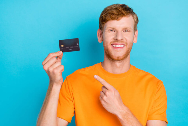 Photo of cute ginger hair guy index card wear orange t-shirt isolated on teal color background. - Foto, afbeelding