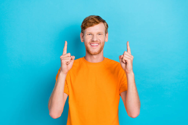 Photo of positive funky guy good mood raise two arm demonstrate empty space show promo banner billboard isolated on cyan color background. - Foto, Imagem