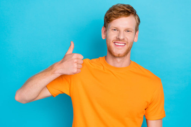 Photo of handsome attractive guy with ginger haircut dressed yellow t-shirt showing thumb up like isolated on teal color background. - Foto, Imagem