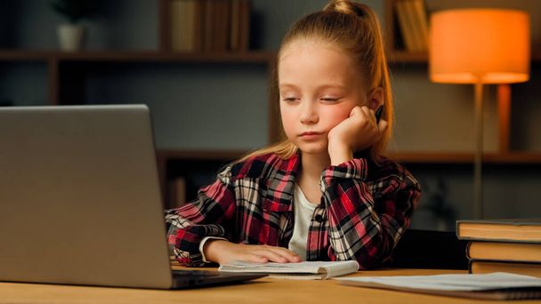Weary sleepy caucasian young child blonde little lazy tired girl studying routine online elementary educational lesson on laptop napping at home feeling boredom chronic burnout fatigue after computer - 写真・画像