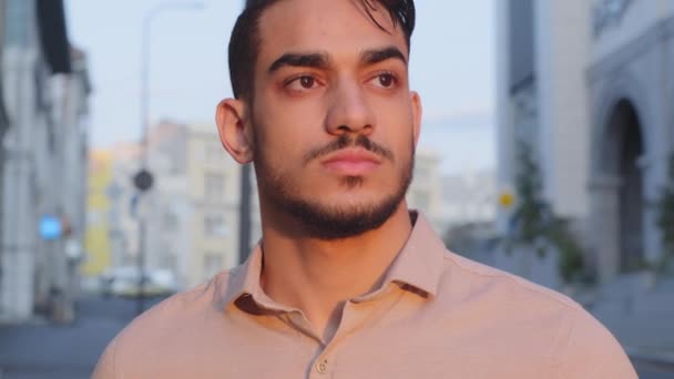 Close up front view Hispanic Latina pensive thoughtful business man in shirt looking away dreaming standing in city with serious face. Portrait of millennial guy boos leader planning thinking outdoors - Footage, Video