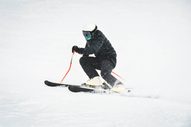 Профессиональный горнолыжник на полной скорости на свежем снегу делает резьбу на горнолыжном курорте во время подготовки к соревнованиям на горнолыжном курорте Гудаури в Грузии - Фото, изображение
