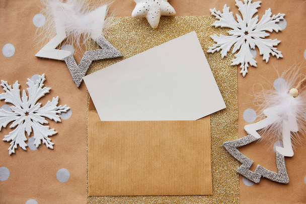 Üdvözlet, kézműves levélpapír, boríték mockup. Trendi karácsonyi dekorációk alapvető háttérrel. Esztétikai ünnepi hangulat. Üdvözlőlap koncepció küldése karácsonyra. Kilátás felülről - Fotó, kép