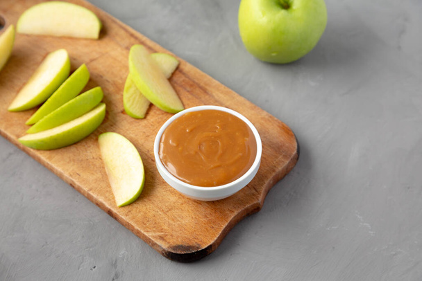 Homemade Caramel Apple Dip on a rustic wooden board, low angle view. Space for text. - Photo, Image
