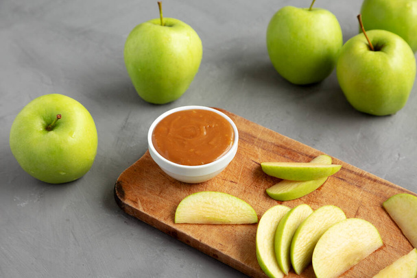 Homemade Caramel Apple Dip on a rustic wooden board, side view.  - Photo, Image
