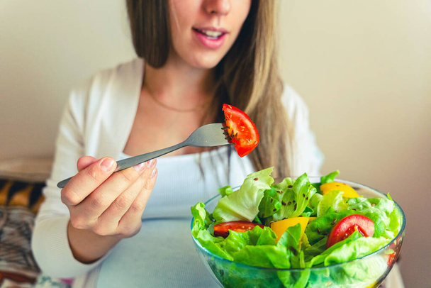 Pregnant woman eating healthy food. Happy pregnancy mother eating nutrition diet salad. Healthy breakfast food concept - Fotó, kép