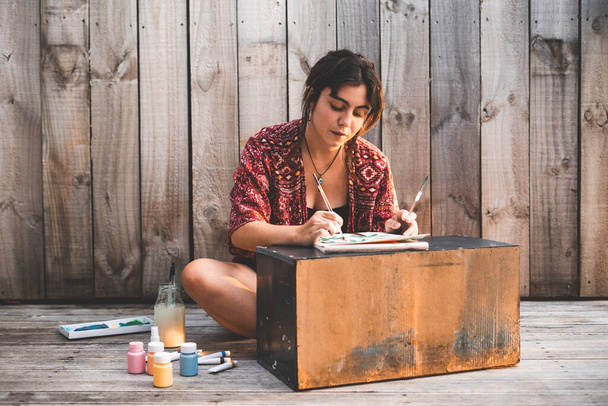 Young woman painter painting a canvas at sunset - Lifestyle concept - Photo, Image