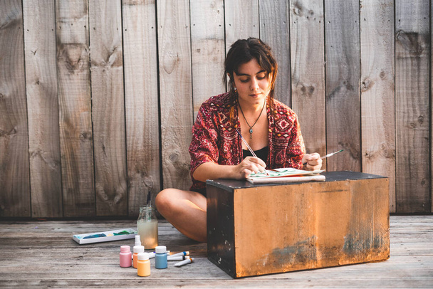 Молода дівчина малює полотно на маленькому столі концепція способу життя
 - Фото, зображення