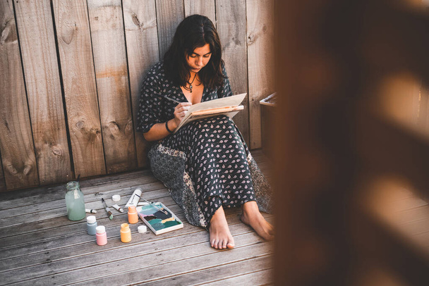 Menina pintando uma tela descalça ao pôr do sol - Conceito de estilo de vida - Foto, Imagem