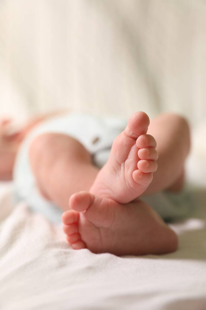 Cute newborn baby lying on bed, closeup of legs - Zdjęcie, obraz