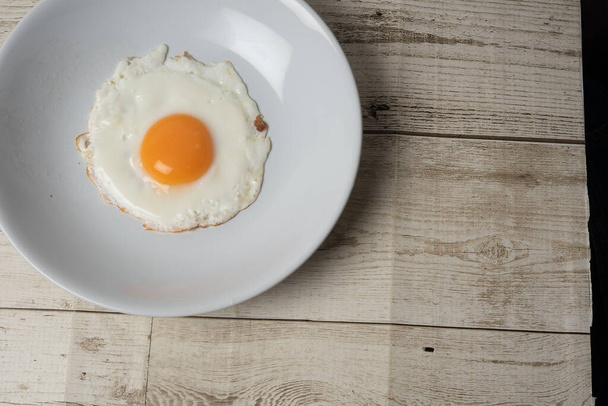 street food, fried egg, fried egg, oil-free fried egg, slow cooker, healthy technology, healthy technology, on the background, black background, wooden floor, high resolution photo - Photo, Image