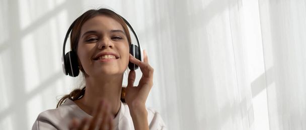 Happy young asian woman wearing headphones listening music while dancing and singing with fun and enjoy in the living room, happiness female with entertainment, one person, lifestyles concept. - Fotografie, Obrázek