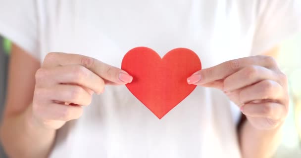 Woman holds red heart drawn on paper closeup. Valentine day and love - Footage, Video