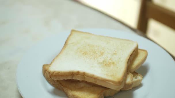 Frisches Toastbrot in weißen Teller geben, fertig für gesunde Mahlzeiten nach dem Toasten aus dem Ofen - Filmmaterial, Video