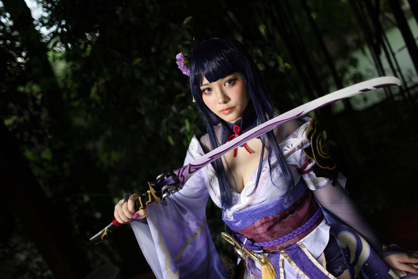 日本庭園に侍の衣装を着た美しい若い女性のゲームコスプレの肖像 - 写真・画像