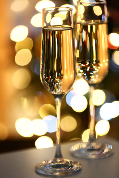 Два бокала шампанского на столе на ярком фоне
 - Фото, изображение